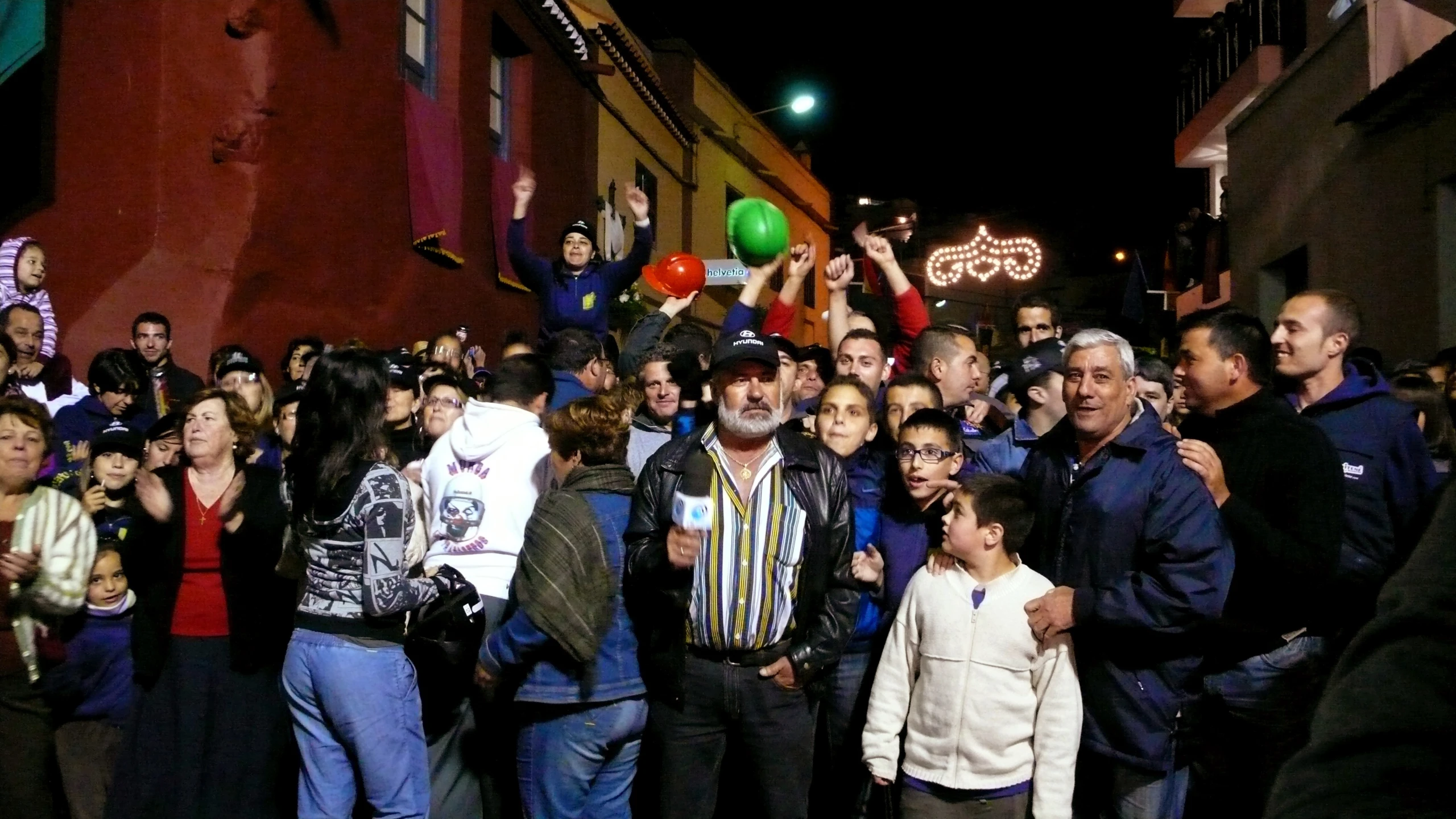 people standing together in the street with people waving at them