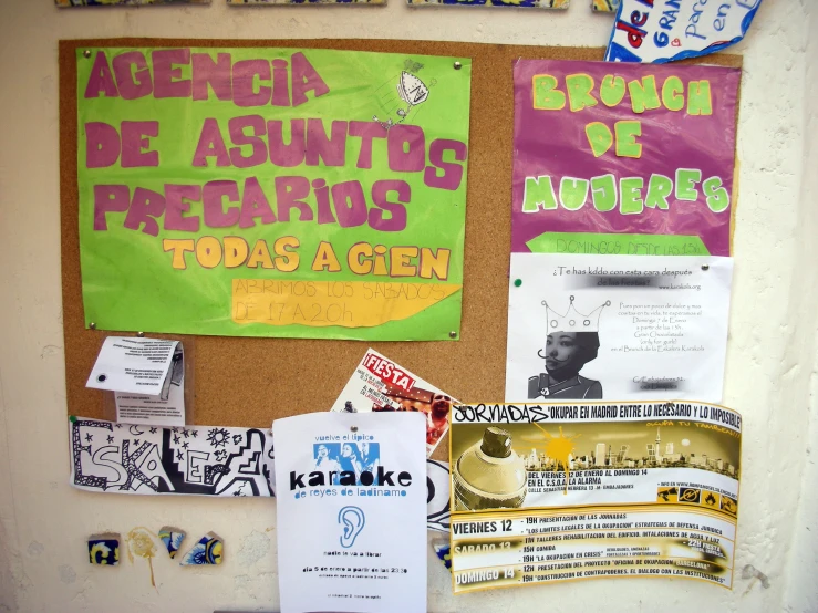 a bulletin board covered in papers and signs