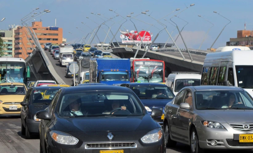 several cars and trucks are going over a bridge