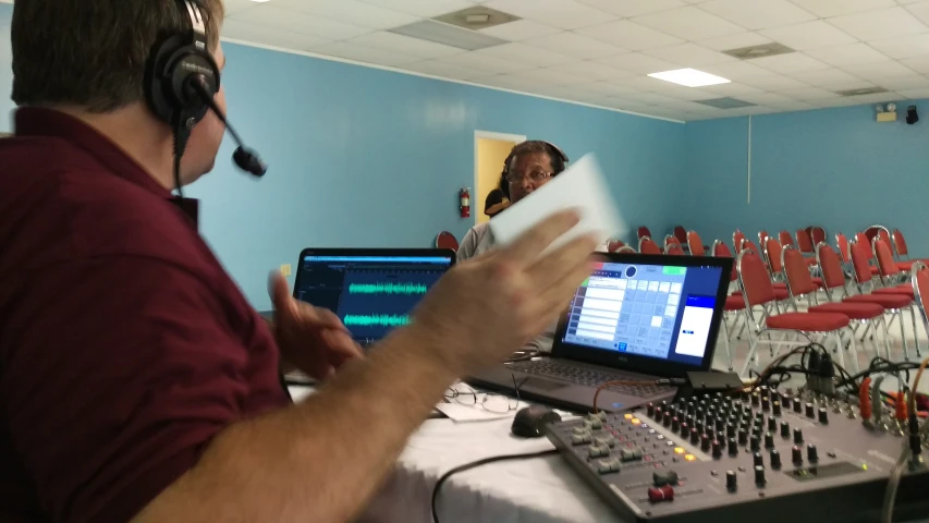 a man recording in front of a laptop