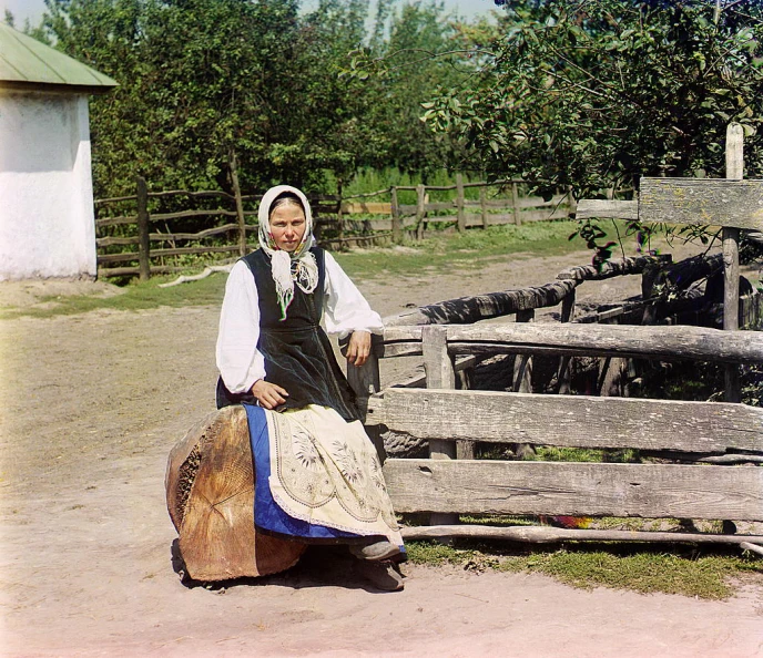 woman in ethnic attire standing near rustic fence