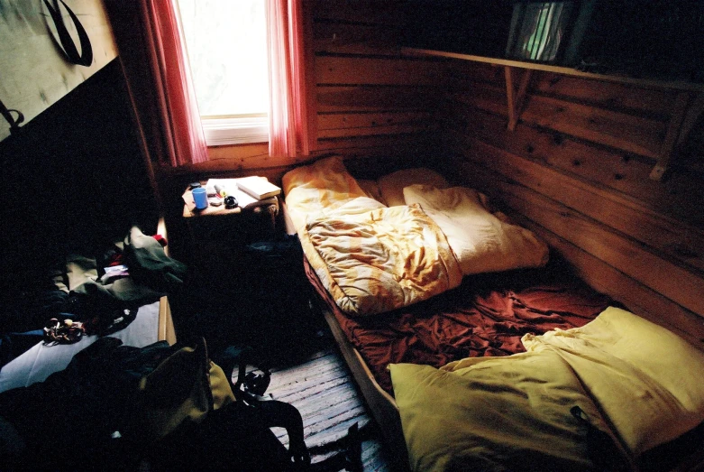 a small bedroom with an old style bed and wooden walls