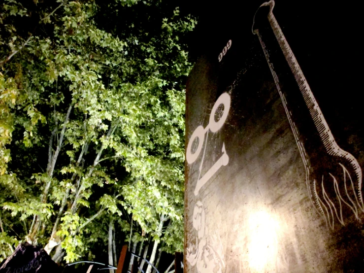 a black and white clock tower near a tree