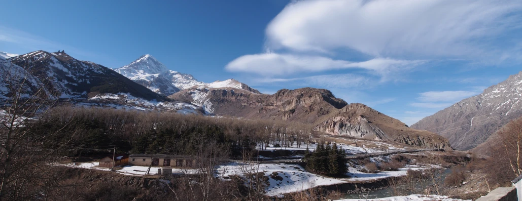 a snow covered hill side with a snowy river