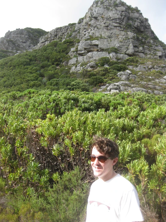 a man standing in front of a very large mountain