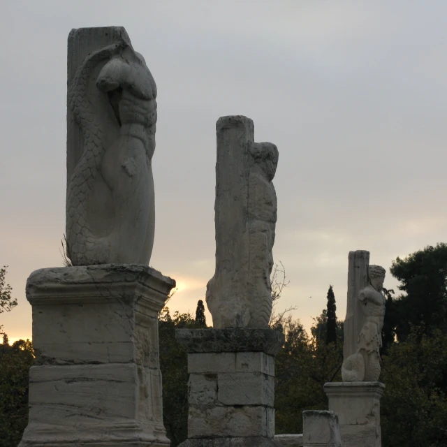 several stone statues sitting on top of cement pillars