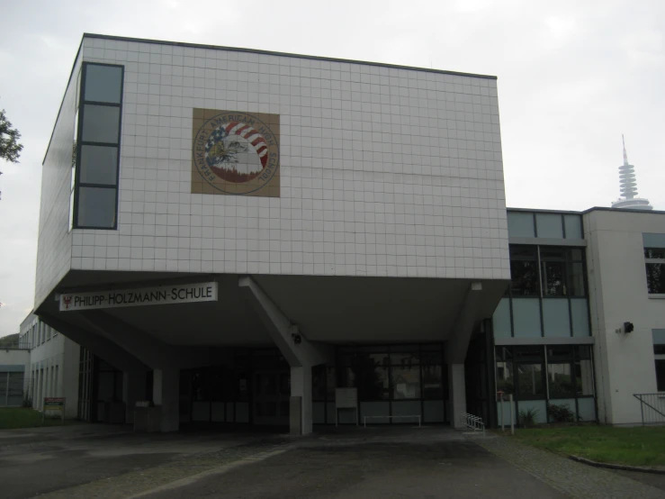 the large white building with the entrance to it is standing next to tall windows