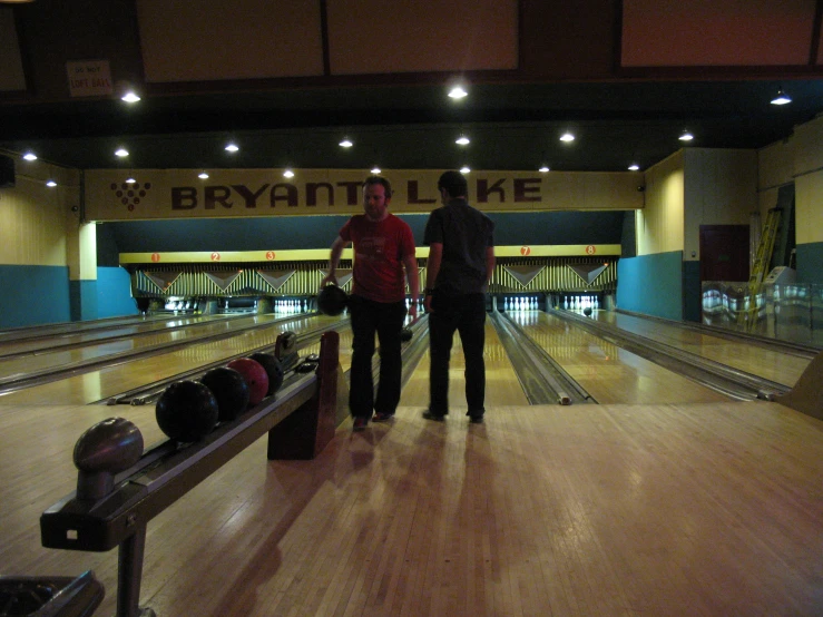 a couple stand near the bowling alley at a bowling club