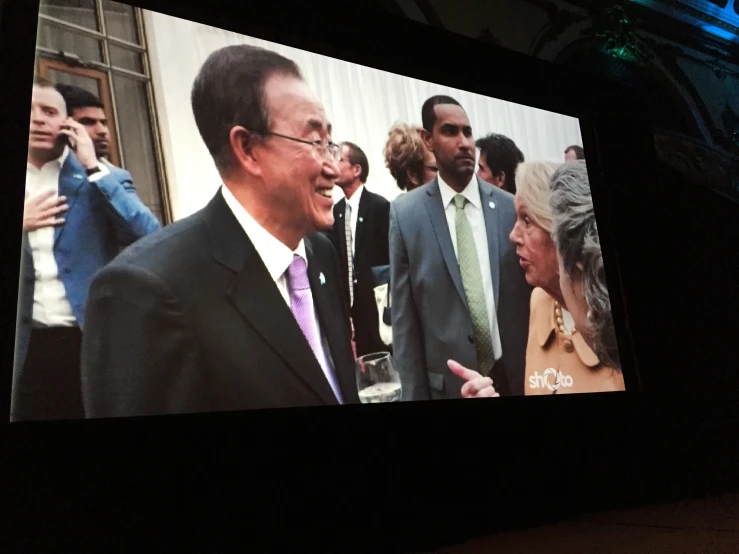 a screen showing images of politicians and people on the street