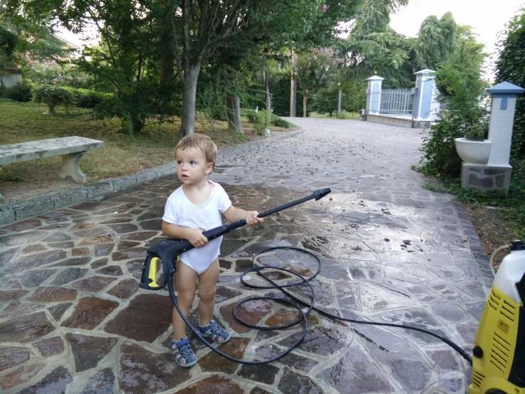 a small child holding a water hose