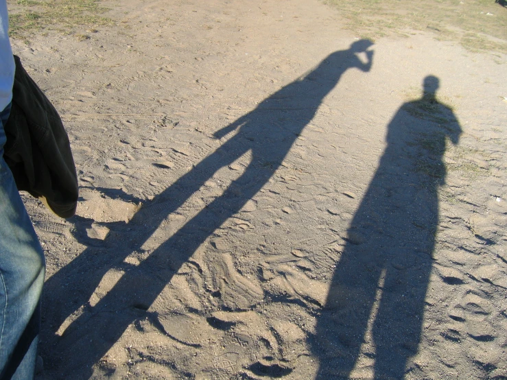 shadow of the person holding the long arm of a man