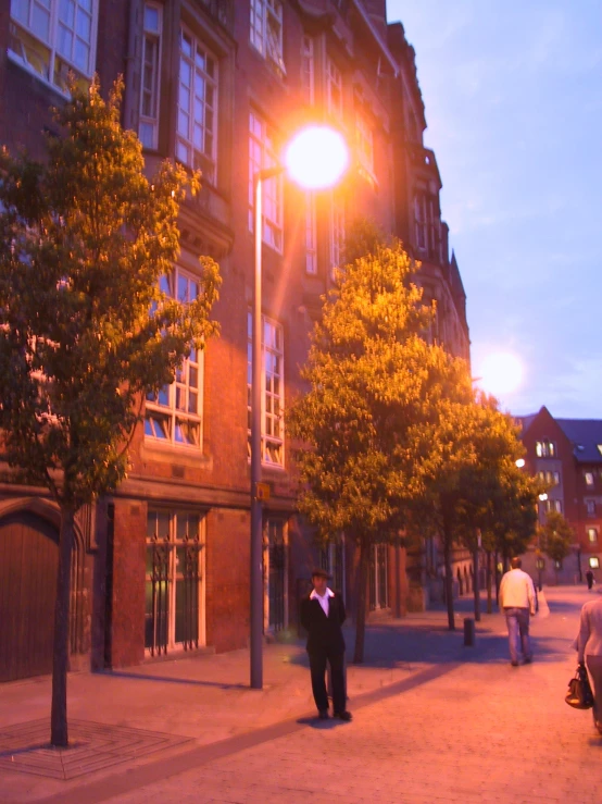 two people are standing on the street at night