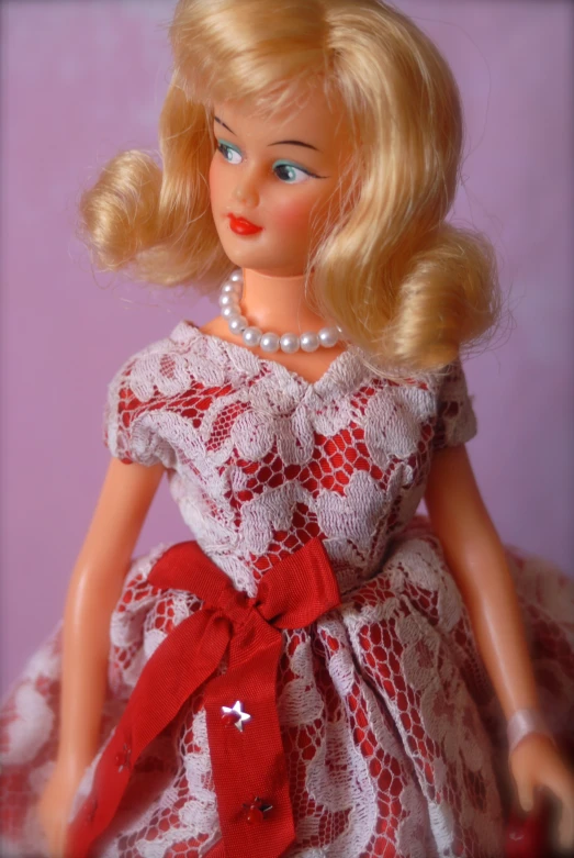 a blonde girl with a red ribbon wearing a dress