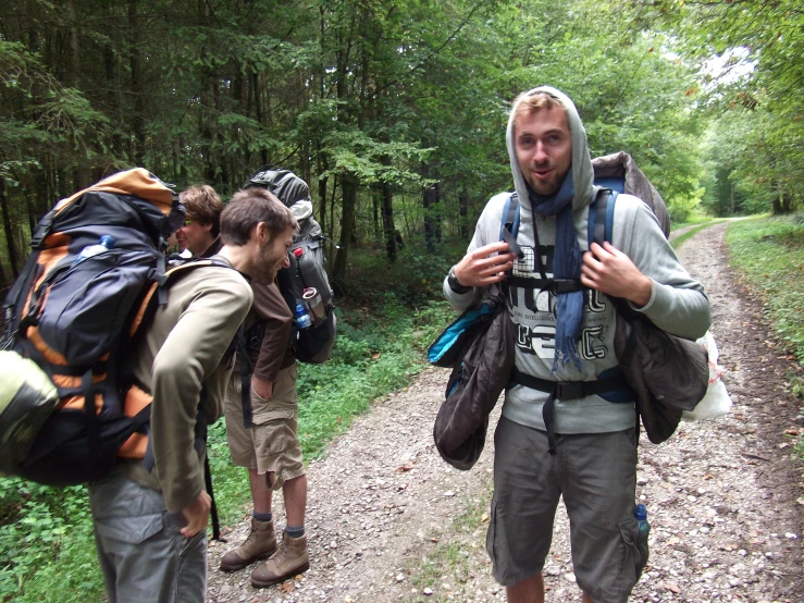 a couple of men with backpacks are on the side of a trail