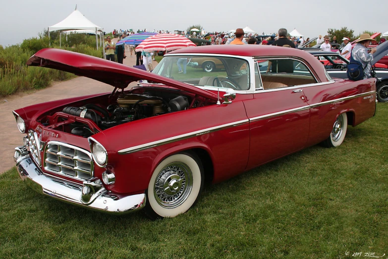 an old red car with its hood open