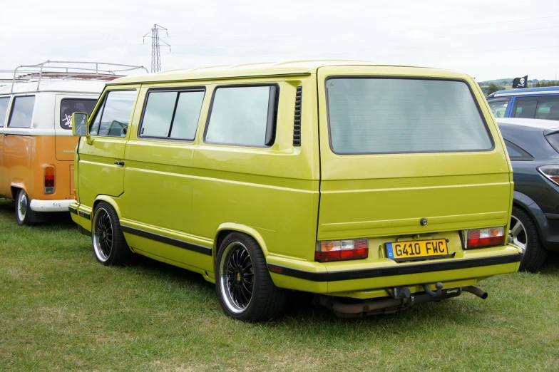 there are many vans parked in a line on the grass