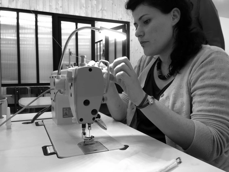 black and white pograph of a woman working on a sewing machine