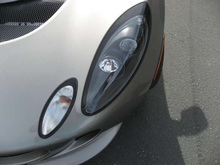 the car's front light is partially exposed on a street