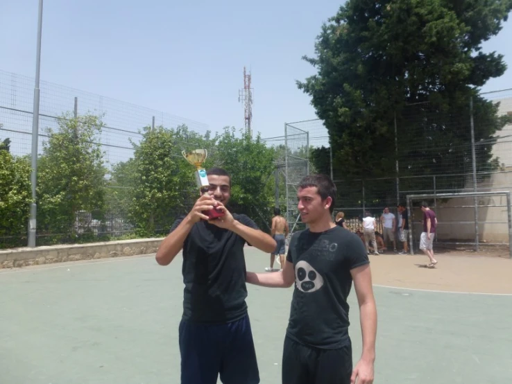 two men on a court with a trophy in their hands