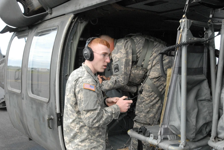 a man sitting inside of a military helicopter