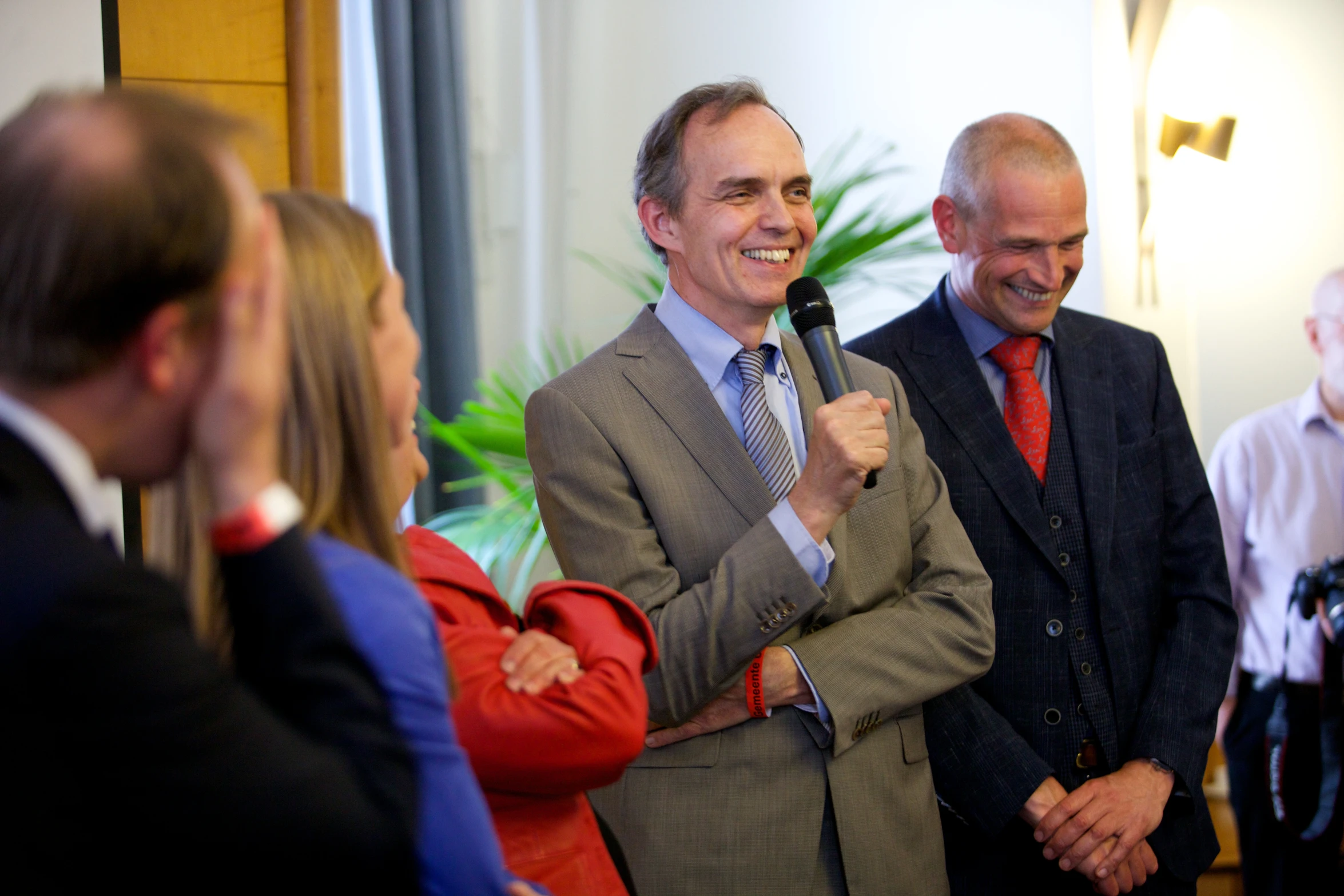 two men stand together, one holding a microphone