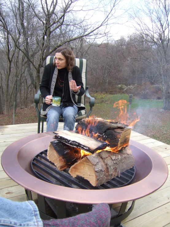 a person sitting on a chair in front of a fire pit