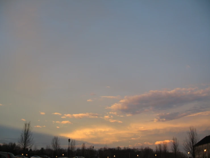 the evening sky with cars in a parking lot