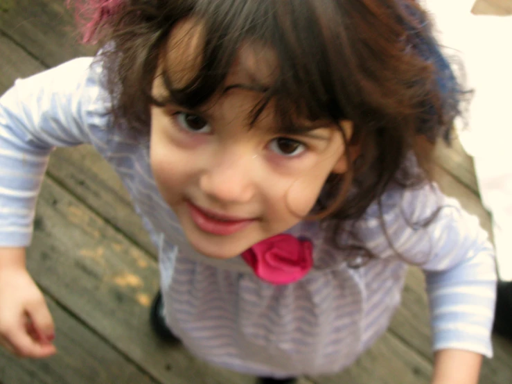 small girl in white shirt and pink flower in her hair