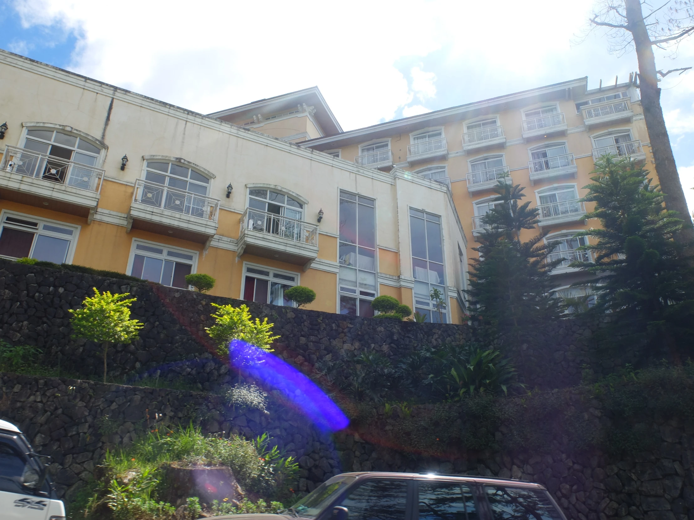 a brown building with three stories and trees