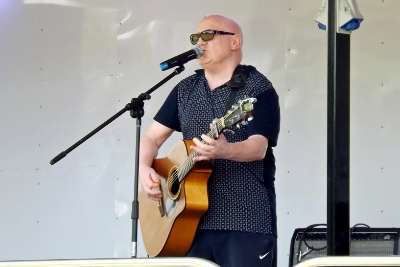 a man on stage with an acoustic guitar