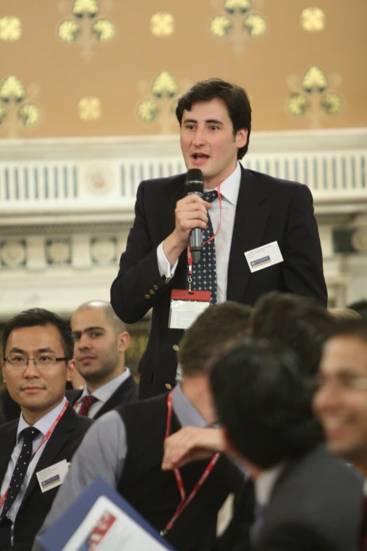 a man in a suit speaking into a microphone