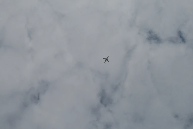 an airplane flies through the cloudy skies