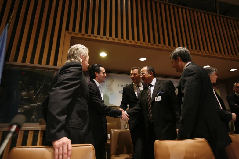 several men standing in a room shaking hands