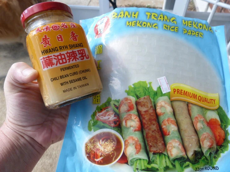 a person holds a packaged oriental meal in their hand