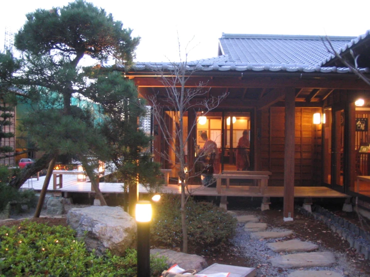 a wooden cabin is set next to a lit up tree