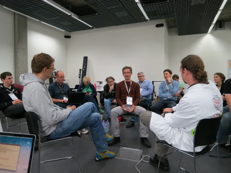 a group of men are sitting on chairs in a room