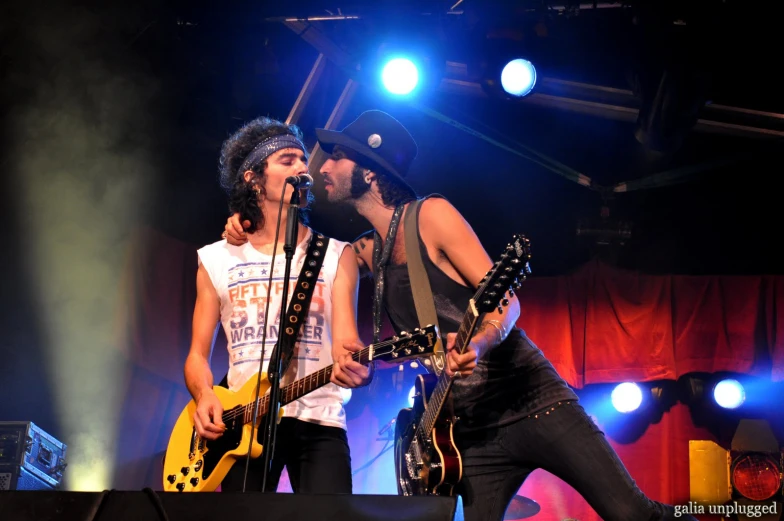 two young men with electric guitar and bandleader at concert