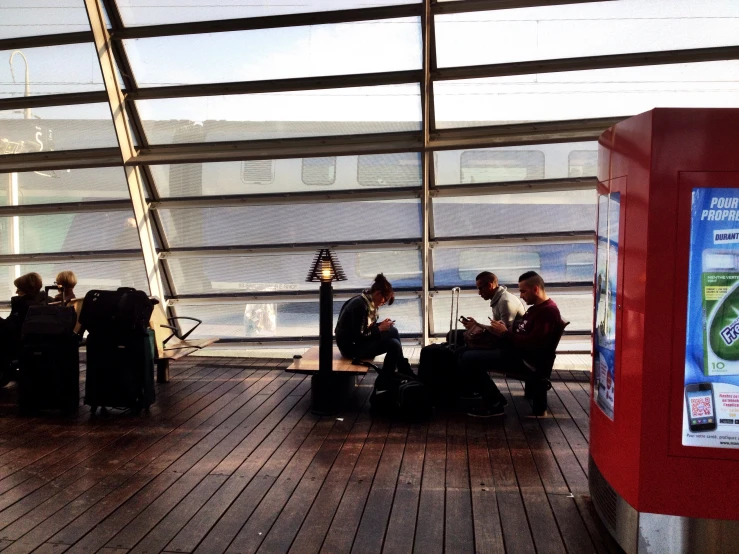 a man and woman sit on benches with a glass covering over them