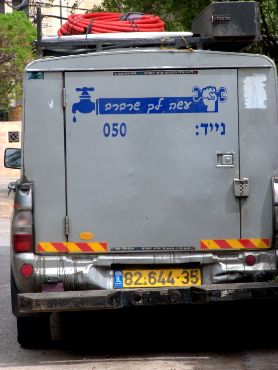 a small cargo truck sits parked on the side of the street