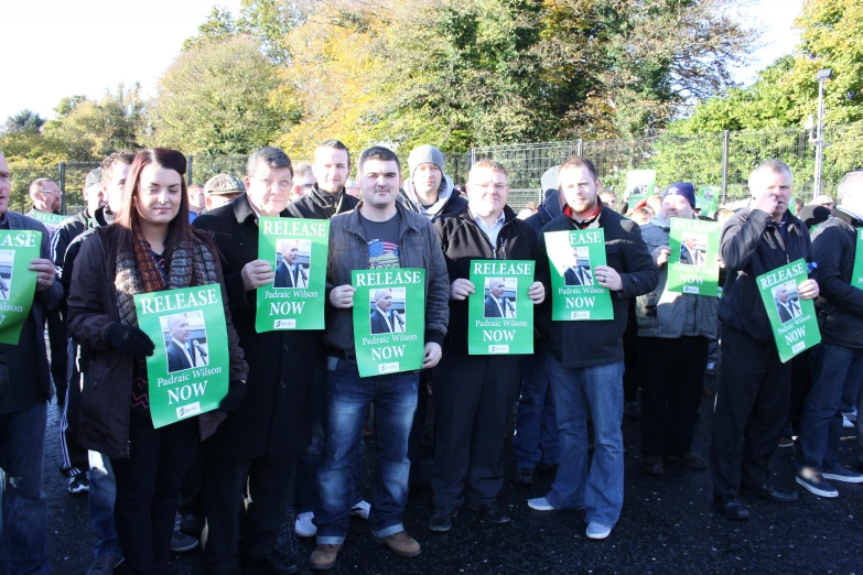 several people with green signs in front of them