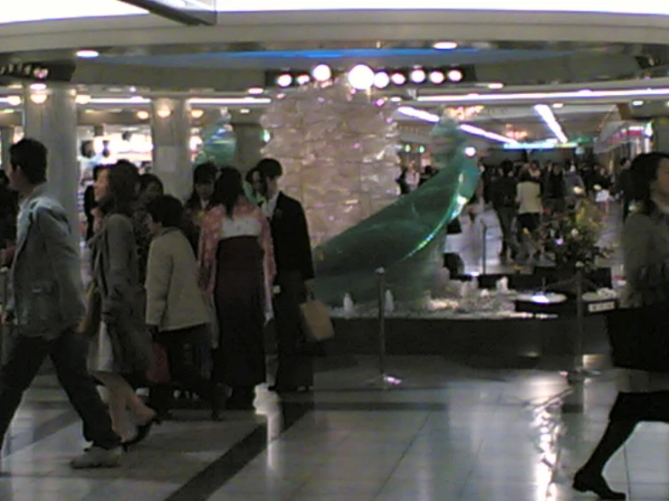 a large group of people are walking through the mall