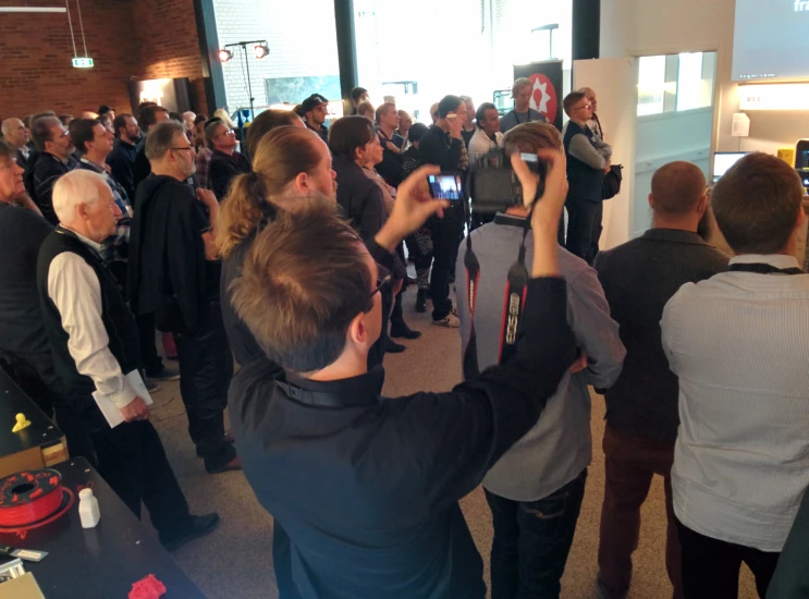 a man standing in a group of people holding onto cell phones