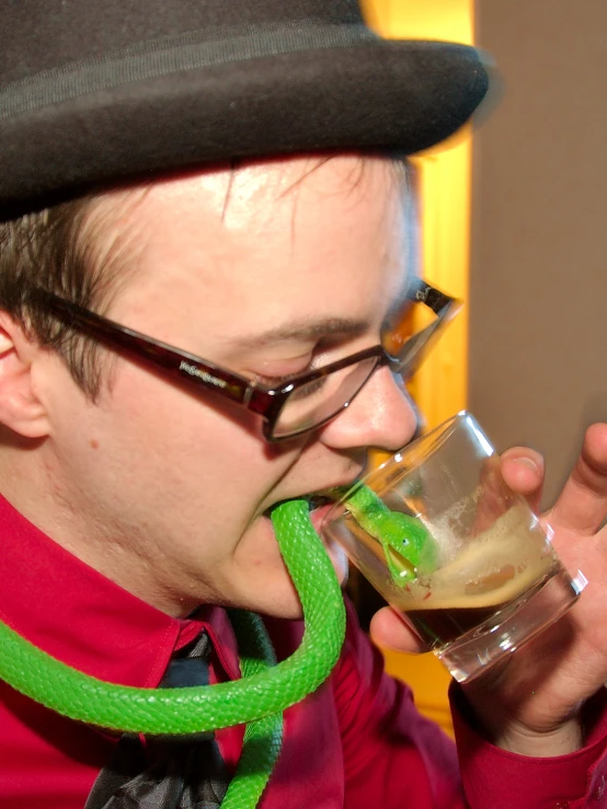 a man with a funny look on his face drinking soing in a glass