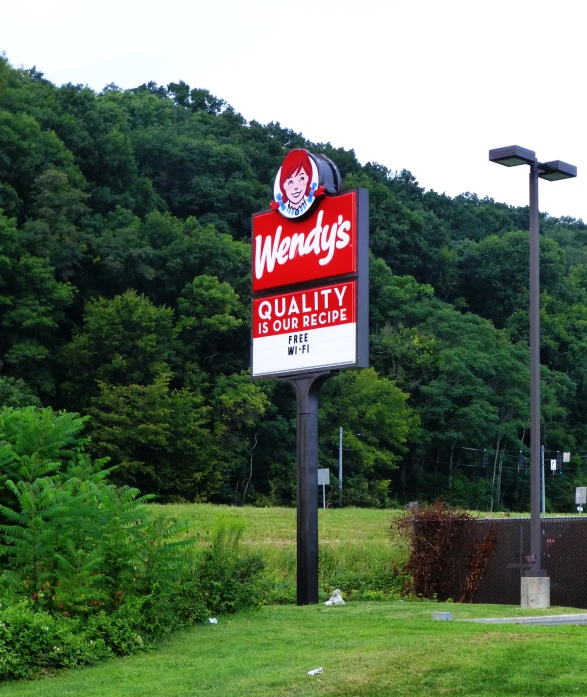 a burger joint with a sign advertising for wendy's