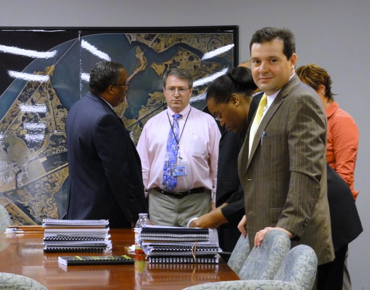 three business people at a table with a sign