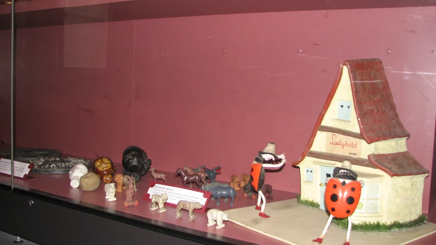a collection of toy figurines, including ladybugs and a small house