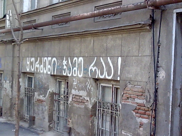 a grey wall with many window windows and metal bars