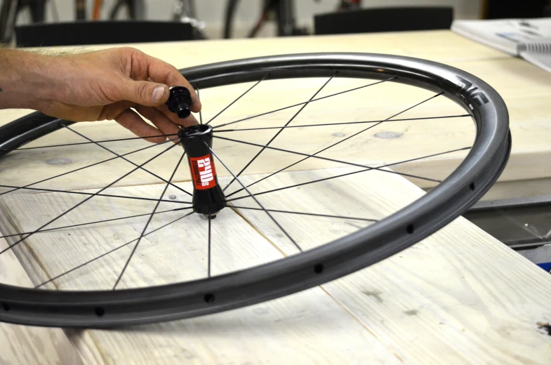 someone working on a bicycle wheel in a shop