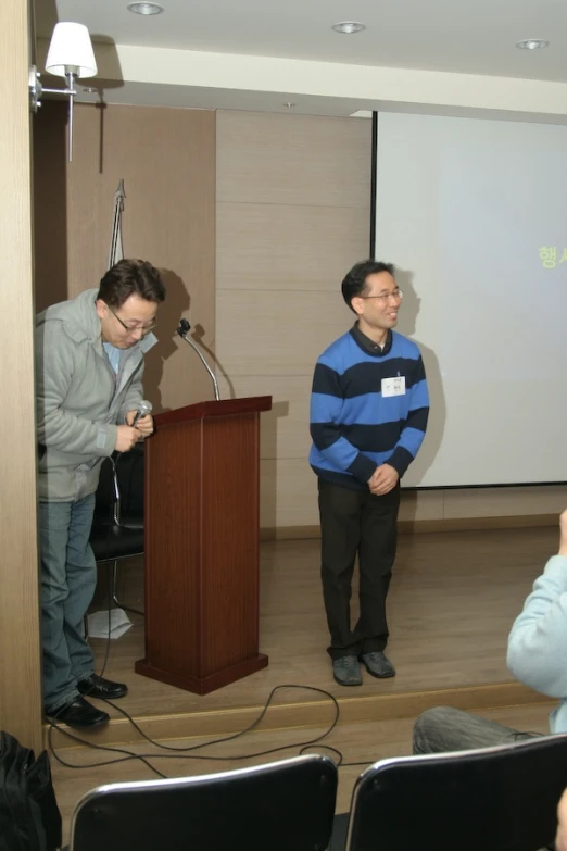 the three men stand and talk in front of the room