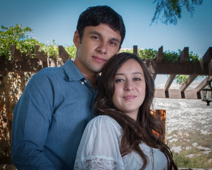 a woman with her arm around a man's shoulder, while he's emcing him